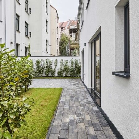 Remise Hof - Weiße Fassade eines zweistöckigen Gebäudes mit mehreren Fenstern, Glastür