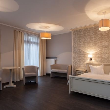 Ein Hotelzimmer mit einem Bett, einem Stuhl und einer Lampe, gemütlich und einladend eingerichtet.