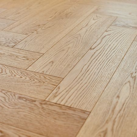 Detailansicht eines Holzfußbodens, der die natürliche Struktur und Farbe des Holzes zeigt.