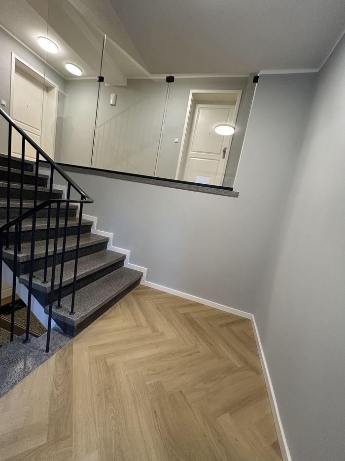 Eine Treppe mit schwarzen Geländern und einem Marmorboden.