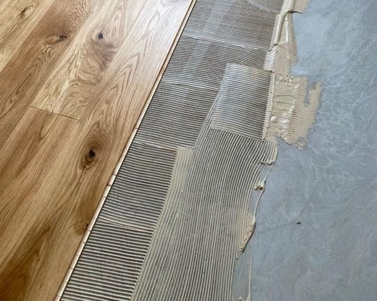 Ein Holzboden mit einem Stück Holz darauf.