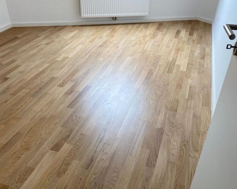 Ein Raum mit Holzböden und einem Heizkörper.